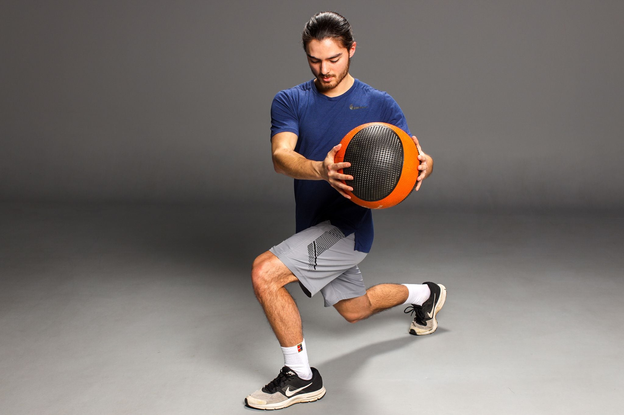 Trainer performing ball lunges for balance