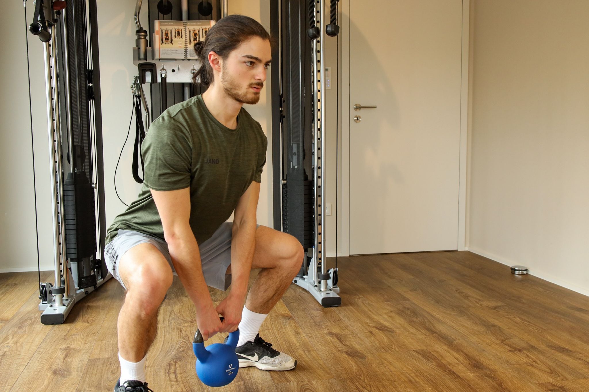 Trainer performing kettlebell squats